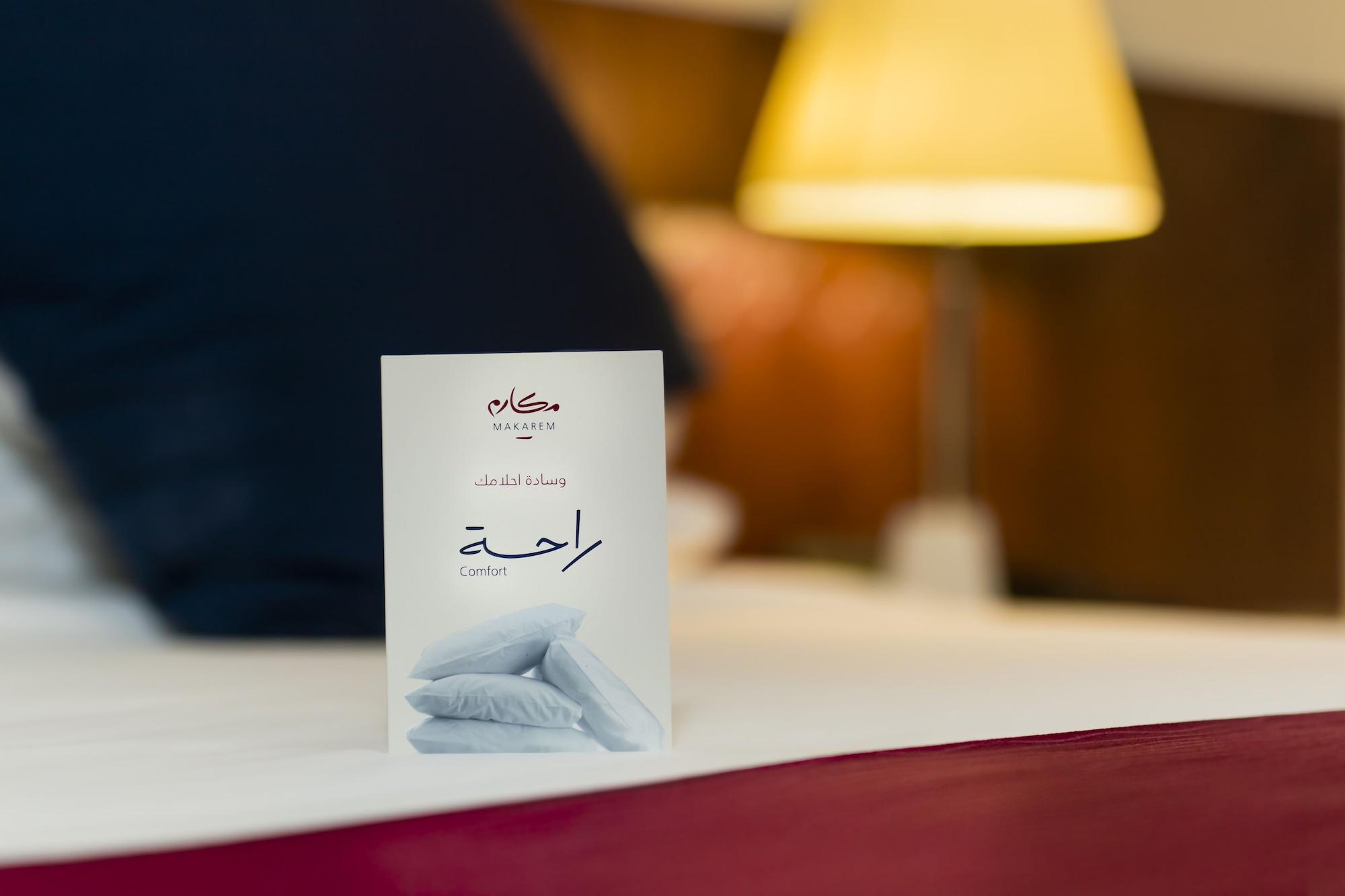 Makarem Umm Al Qura Hotel Mecca Exterior foto The photo shows a neatly arranged hotel bed with a white card placed in the foreground. The card features an elegant design, likely indicating a message or information related to the hotel. The Arabic word "راحة" is printed on it, which translates to