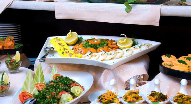 Makarem Umm Al Qura Hotel Mecca Exterior foto The photo showcases an elegantly arranged seafood platter. It features various types of sliced fish, likely including smoked salmon and other seafood options, garnished with fresh herbs and lemon slices. The platter is white and triangular in shape, 